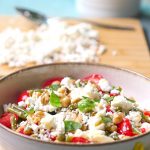 Insalata fresca estiva con ceci, pomodorini, feta, basilico e fagiolini cotti.